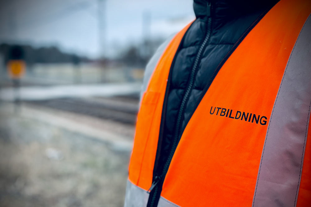 En orange väst med utbildning printat på